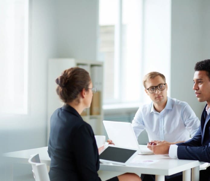 A group of people sitting at a table talking.